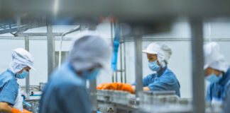 Masked workers labor at a factory in China