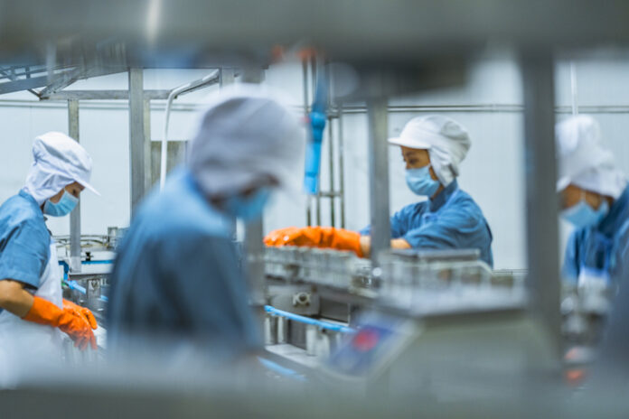 Masked workers labor at a factory in China