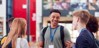 Fahim Imam-Sadeque Discusses How Children of Immigrants Are More Likely to Get Higher Education in the UK Group Of College Student Friends Meeting And Talking In Busy Communal Campus Building