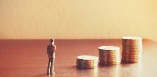 Miniature people looking future with stack coin about financial and money savings concept.