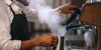 Barista making a cup of coffee in machine