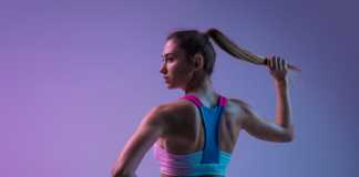 Young sportive woman training isolated on gradient studio background in neon light. athletic and graceful