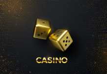 Golden dices on black background with golden glitters.