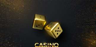 Golden dices on black background with golden glitters.