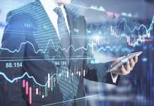 Investment business concept: businessman with smartphone and digital screen with financial chart graphs, candlestick, and diagram