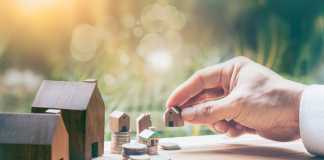 House placed on coins Men's hand is planning savings money of coins to buy a home concept concept for property ladder, mortgage and real estate investment. for saving or investment for a house,