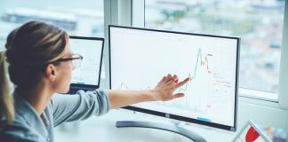 How to Start Cryptocurrency as a Beginner? Business woman study financial market to calculate possible risks and profits.Female economist accounting money with statistics graphs pointing on screen of computer at desktop. Quotations on exchange
