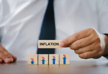 Businessman Hand holding a wooden block with the word inflation. and wood block with sign percent and arrow up symbol. financial growth, interest rate increase, inflation concept