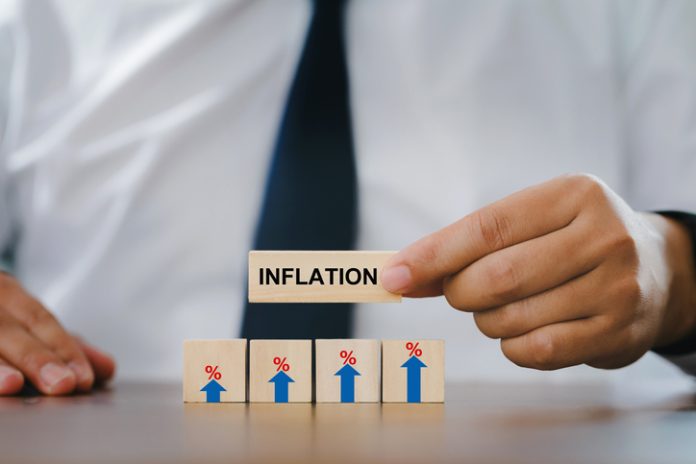 Businessman Hand holding a wooden block with the word inflation. and wood block with sign percent and arrow up symbol. financial growth, interest rate increase, inflation concept