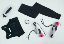 flat lay with sportswear with sneakers, fitness tracker and sports bottle isolated on grey