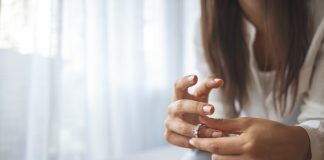 What Are Worry Rings? Unhappy woman holding wedding ring close up