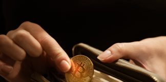 Bitcoin on the Move to the Next Crypto Revolution Woman puts gold bitcoin coin in her purse, close up hands shot
