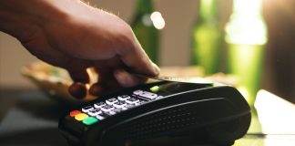 Credit card machine for money transaction. Close up of male hold in hand wireless modern bank payment terminal to process acquire credit card payments black card. Credit card through pos terminal