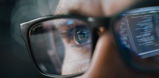 Close-up Portrait of Software Engineer Working on Computer, Line of Code Reflecting in Glasses. Developer Working on Innovative e-Commerce Application using Machine Learning, AI Algorithm, Big Data