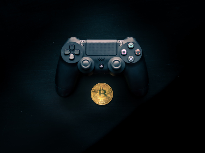 Bitcoin sitting underneath a Playstation 4 Controller