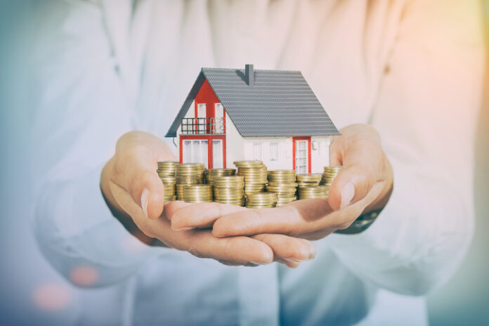 Mortgage concepts. House and money coins on hand. wealth management
