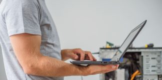 Man holding laptop to diagnose problem