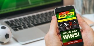 Cropped shot of male hands holding smartphone with bookmaker's mobile application interface design template