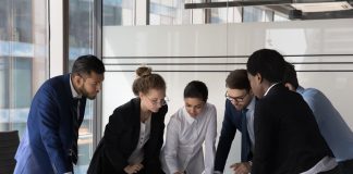 Multiracial staff members cooperate together gather in boardroom at briefing
