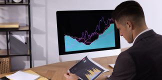 Businessman working with computer and graph in office, space for text. Forex trading