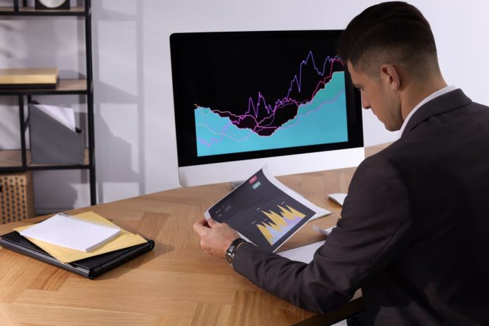Businessman working with computer and graph in office, space for text. Forex trading