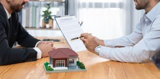 Client review loan contract with real estate agent and discussing term. Fervent