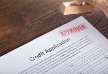 Get Approved for Bad Credit Equipment Financing- Avoid These Common Errors! Person Holding Stamp On Credit Application Form