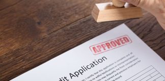 Person Holding Stamp On Credit Application Form