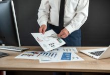 businessman work alone with business document graph and statistic with computer at office.