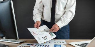 businessman work alone with business document graph and statistic with computer at office.
