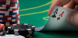 hand raises for two winning cards on a green poker table