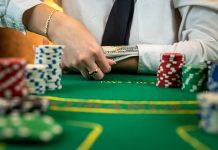 Greedy poker player after winning the game takes chips on a hundred dollar bill from the table. stock photo
