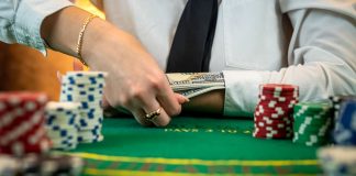 Greedy poker player after winning the game takes chips on a hundred dollar bill from the table. stock photo