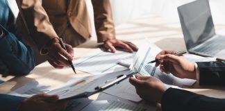 Business people meeting to plan, analyze and point to graph and chart about business growth to plan future expansion of new business.