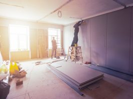 Everything You Need to Know about Building Maintenance Workers are installing plasterboard (drywall) for gypsum walls in apartment is under construction, remodeling, renovation, extension, restoration and reconstruction.