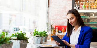 Girl in a cafe reads something on the tablet
