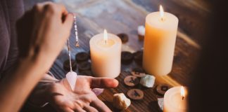 candles, stones and pendulum over the hand