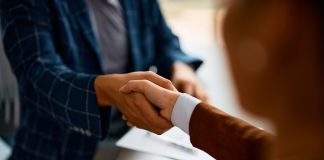 Close up of business people shaking hands in the office.