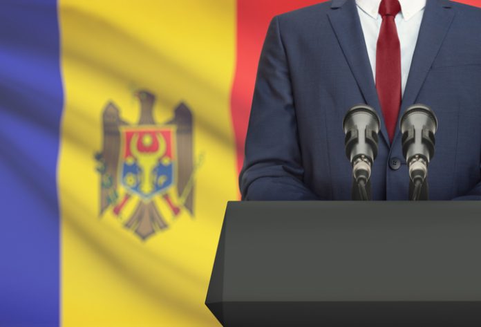 businessman making speech behind the flag of moldova