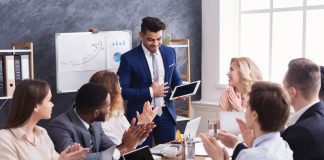 Business people applauding for colleague after presentation in office