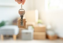 Moving house, relocation. Man hold key house keychain in new apartment. move in new home. Buy or rent real estate. flat tenancy, leasehold property, new landlord, investment, dwelling, loan, mortgage.