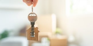 Moving house, relocation. Man hold key house keychain in new apartment. move in new home. Buy or rent real estate. flat tenancy, leasehold property, new landlord, investment, dwelling, loan, mortgage.