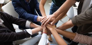 Top view hands stacked together as symbol of teambuilding