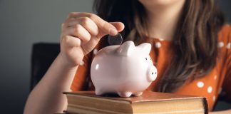 woman puts coins in the piggy bank for eduqation