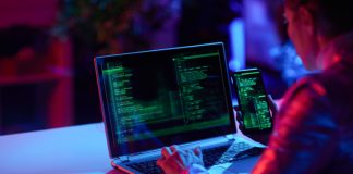 Seen from behind modern female with laptop developing app