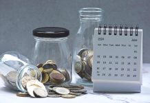 June 2024 calendar and glass jars with multicurrency coins. 2024 finance concept.