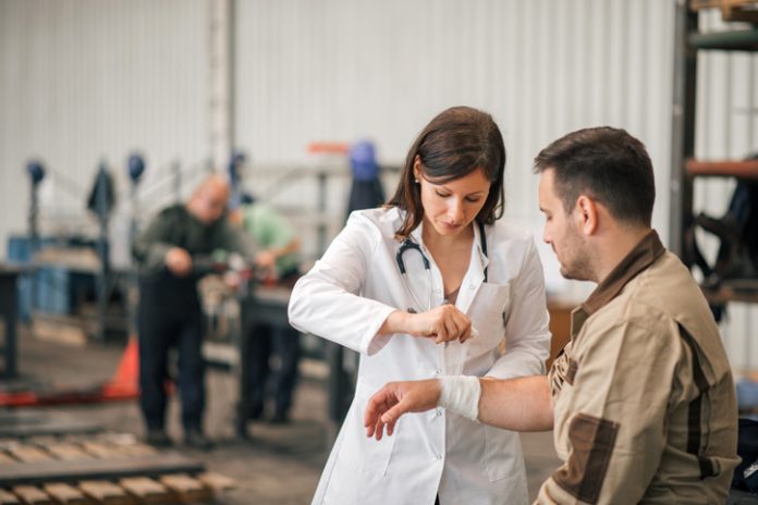 Female doctor examining factory worker