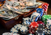 GamblingSA.co.za Votes Springbok Casino as the Fastest Payout Casino for 2024 Colorful poker chips with playing cards and american dollars on dark background.