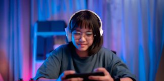 Asian girl playing game on phone at night having fun