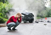 Woman making a phone call after a car accident